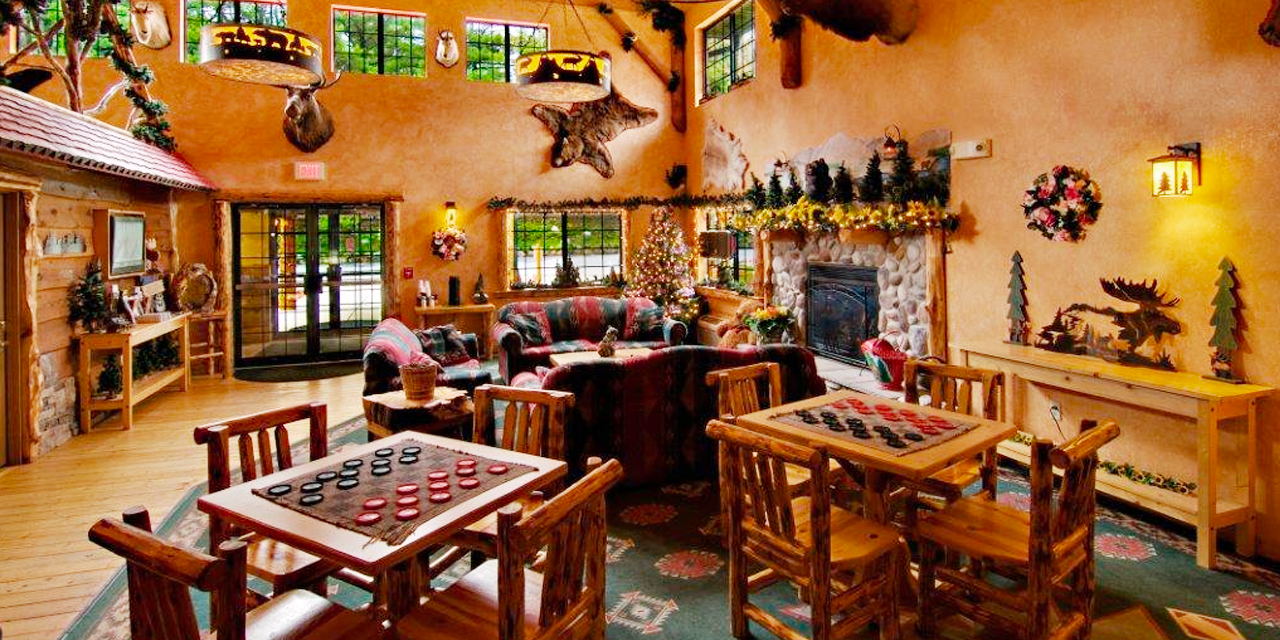 Cabin theme interior with pine tree decorations and stone fireplace.