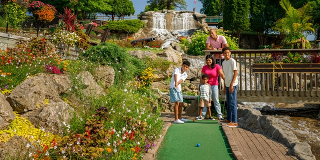 Family playing mini-golf in a gorgeous landscape setting.
