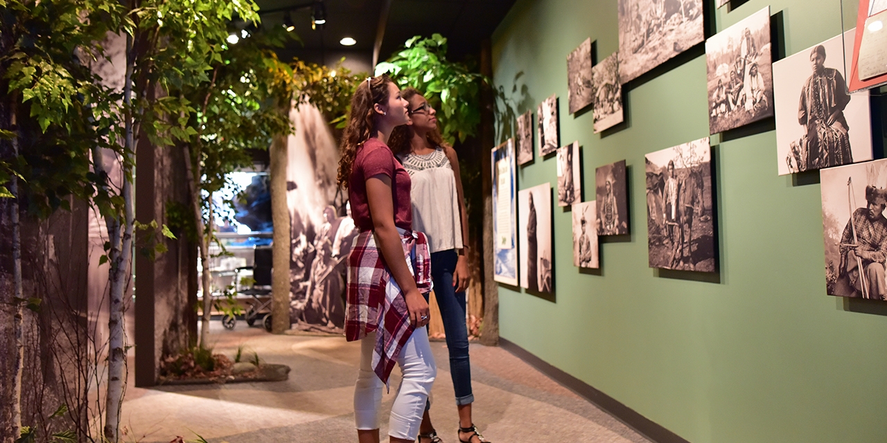 Two girls look at historical images at the H.H. Bennett Studio & Museum.