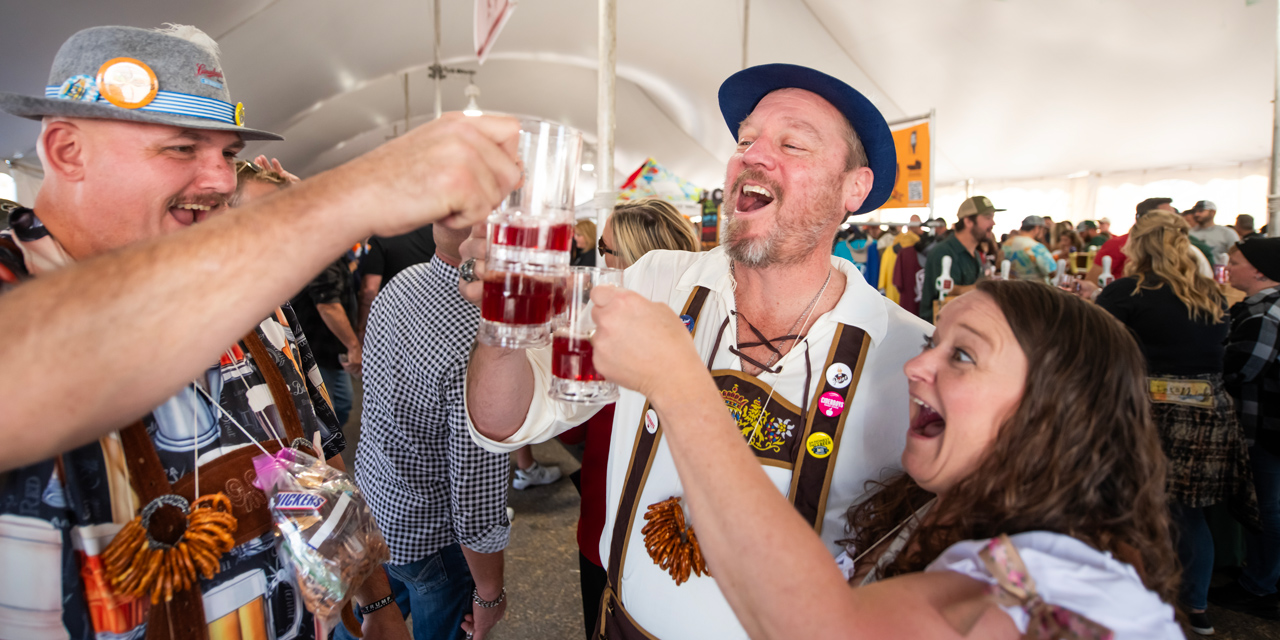 People cheering inside a beer tent.