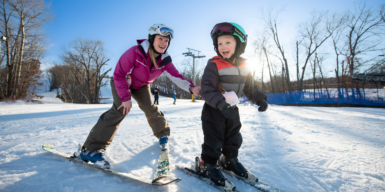 Mother and son downhill skiing.