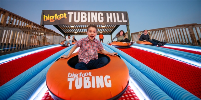 Group of people taking off a tubing hill.
