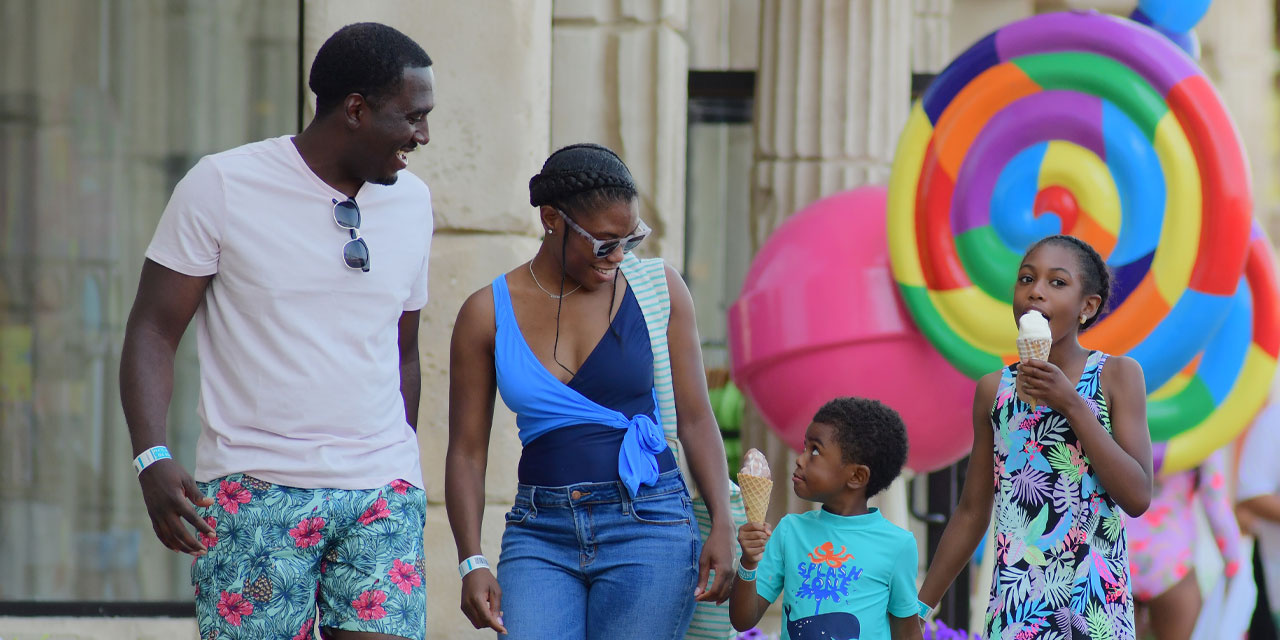 Family walking through a theme park with an ice cream.